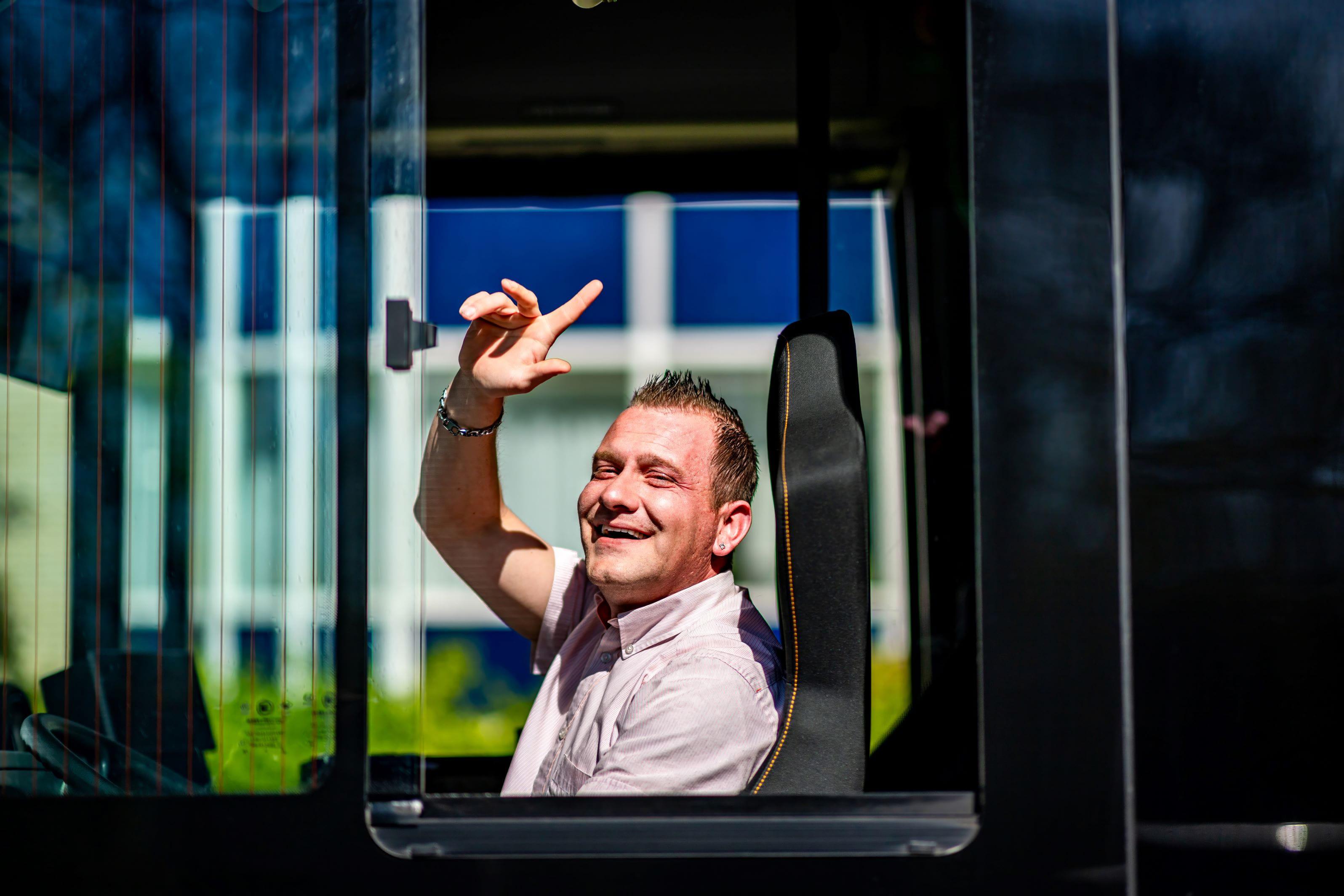 Qbuzz buschauffeur zwaait uit het raam