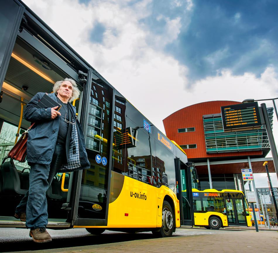 Reiziger met Ipad stapt uit de bus in Utrecht